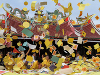 Indonesian Chinese community in the form of paper throwing money into the air during the celebration of the Hungry Ghost Festival is held at...