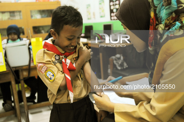 The faces of elementary school students (SD) 03, when Health Officers gave an injection of Measleas Rubela immunization in Bukit Duri, Jakar...