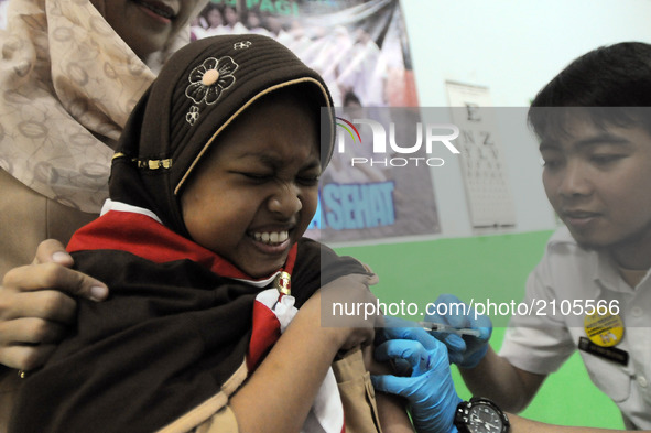 The faces of elementary school students (SD) 03, when Health Officers gave an injection of Measleas Rubela immunization in Bukit Duri, Jakar...