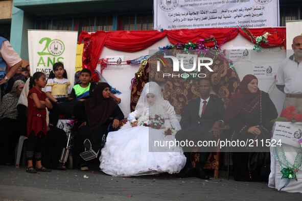 Palestinians celebrate during a party for a bride (C in veil and the groom)   her wedding ceremony at a United Nations-run school sheltering...