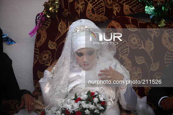 Palestinians celebrate during a party for a bride (C in veil and the groom)   her wedding ceremony at a United Nations-run school sheltering...