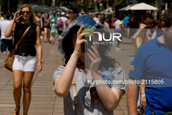 A tourist takes a photo in La Rambla on August 8, 2017,  Barcelona, Spain. In the past year there have been a series of protests as resident...