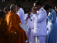 Thai Prime Minister Prayuth Chan-O-Cha gives alms to Buddhist monks to celebrate the Queens Sirikit' 85th birthday in Bangkok, Thailand, 12...