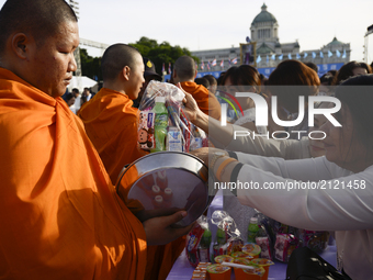 Thai Buddhist devotees give alms to a Buddhist monk as part of celebrate the Queens Sirikit' 85th birthday in Bangkok, Thailand, 12 August 2...