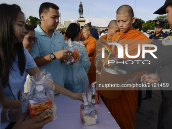 Thai Buddhist devotees give alms to a Buddhist monk as part of celebrate the Queens Sirikit' 85th birthday in Bangkok, Thailand, 12 August 2...