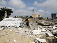 A Palestinian man inspects the damage following a month of fighting between the Israeli military and Hamas militants as he stands close to t...