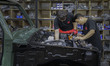 Workers installing engine part at mohenic garages in Paju, South Korea. A 20-year-old beat...