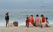 Street vendors gather by the Copacabana Beach while at their lunch break. There are other...