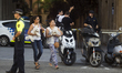 People are escorted by Spanish policemen outside a cordoned off area after a van ploughed...