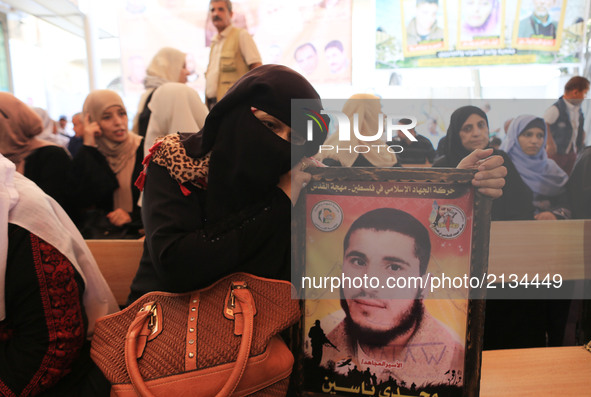 Palestinian families hold posters of their relatives as they gather for a demonstration to show their support for the Palestinian prisoners...