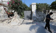 A police member walks near an house, destroyed in the earthquake in one of the more heavil...