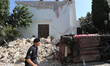 A police member walks near an house, destroyed in the earthquake in one of the more heavil...