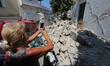A woman take a picture near a damaged building by earthquake in one of the more heavily da...