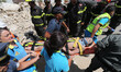 Italian emergency workers evacuate on a stretcher a boy who was was trapped by rubble, in...