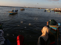  Palestinian activists throw bottles into the sea containing messages against the siege of the Gaza Strip at the port in Gaza City on August...