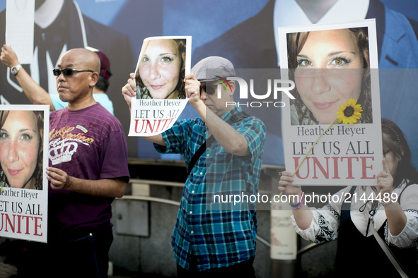 People holds a photo of Heather Heyer during the standing silent appeal, a hundred people gathered in shibuya against racism and violence in...