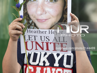A participant holds a photo of Heather Heyer during the standing silent appeal, a hundred people gathered in shibuya against racism and viol...