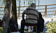 An elderly sits on a stool as people enjoy 10-day holiday for Muslims' traditional festiva...