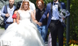 A bride and a groom walk on a path during their wedding ceremony as people enjoy 10-day ho...