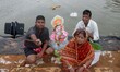 Devotees look on the banks of river Kuakhai as they immerse elephant headed God Ganesha’s...