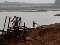 Rag pickers look on the banks of river Kuakhai as they are busy to collect reusable items from the immersion ghat as devotees throw puja rit...