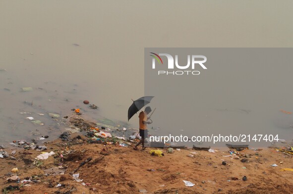 Rag pickers look on the banks of river Kuakhai as they are busy to collect reusable items from the immersion ghat as devotees throw puja rit...