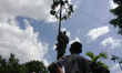 Indonesian men compete for prizes in climbing the greasy pole called "panjat pinang" durin...