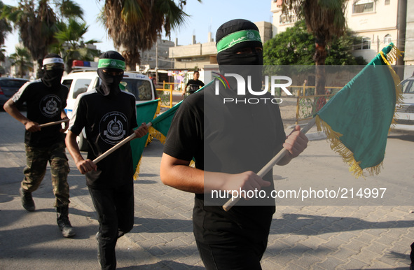 RAFAH, GAZA STRIP, PALESTINE - AUGUST 17:  Masked Hamas members burn a cut-out of a Star of David during a demonstration in support of the H...