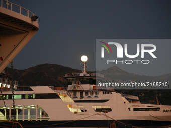 Full moon over Rio (Greece) rising on top of the ships in the harbor, in Rio near Partas 5/6 September 2017(