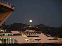 Full moon over Rio (Greece) rising on top of the ships in the harbor, in Rio near Partas 5/6 September 2017(