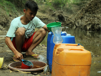 Residents take clean water at a catchment well in the cihoe river that began to recede in Ridogalih village, Cibarusah, Bekasi, West Java on...