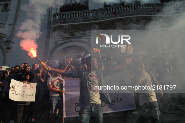 A protester shouts slogans as he holds a smoke grenade during a rally held by the movement "I don't forgive" (Manich Msameh: Arabic) on Sept...