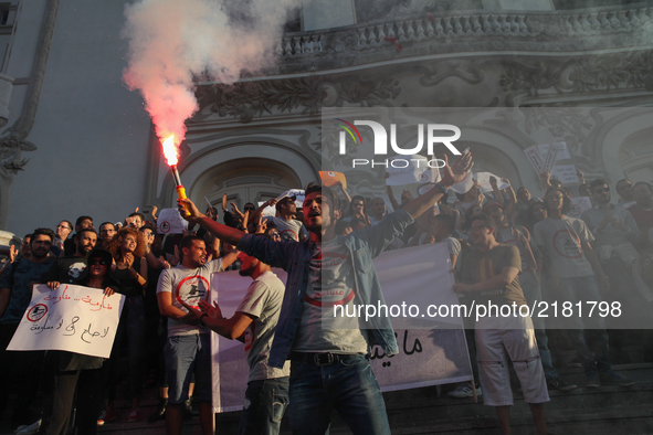 A protester shouts slogans as he holds a smoke grenade during a rally held by the movement "I don't forgive" (Manich Msameh: Arabic) on Sept...