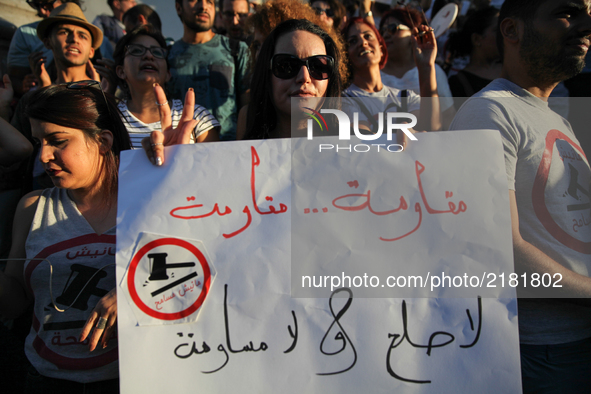 A female protester makes a victory sign as she holds a placard that reads in Arabic "Fighting, no reconciliation, no negotiation" during a r...