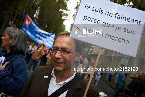 A man holds a placard reading 'I'm lazy as I'm not 'en marche'' (En marche is the name of Macron's political mouvement). More than 10000 pro...
