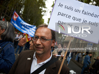A man holds a placard reading 'I'm lazy as I'm not 'en marche'' (En marche is the name of Macron's political mouvement). More than 10000 pro...