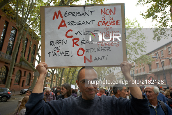 A protester popses with a placard reading 'scornful, arrogant, cynic, reactionnary, lewd, whealthy' with the initials of French President MA...
