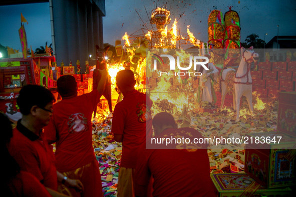 Ethnic Chinese in Malaysia throw a paper offerings a special prayer in front of God of Ghosts paper statue during the Hungry Ghost Festival...