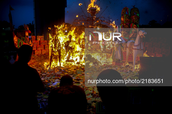 Ethnic Chinese in Malaysia throw a paper offerings a special prayer in front of God of Ghosts paper statue during the Hungry Ghost Festival...