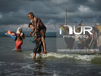 Rohingya Muslim refugees disembark from a boat on the Bangladeshi side of Naf river in Teknaf on September 13, 2017. International divisions...