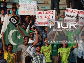 Pakistani spectators hold placards cheering the players as they watching the final match of independence cup 2017, Twenty20 international ma...