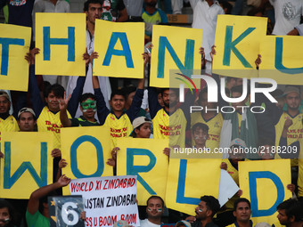 Pakistani spectators hold placards cheering the players as they watching the final match of independence cup 2017, Twenty20 international ma...