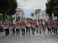 Protesters wearing masks hold shields and sticks as they attend a march held under the slogan ‘firmness against the mafia regime’ by the mov...