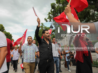 Protesters wave Tunisian flags as they attend a march held under the slogan ‘firmness against the mafia regime’ by the movement "I don't for...