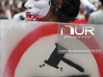 A female protester wearing a mask, holds a shield  as she attends a march held under the slogan ‘firmness against the mafia regime’ by the m...