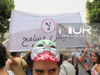 A female protester wearing a mask attends a march held under the slogan ‘firmness against the mafia regime’ by the movement "I don't forgive...