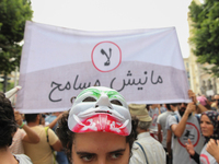 A female protester wearing a mask attends a march held under the slogan ‘firmness against the mafia regime’ by the movement "I don't forgive...