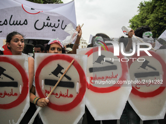 Female protesters wearing masks hold shields and sticks as they attend a march held under the slogan ‘firmness against the mafia regime’ by...