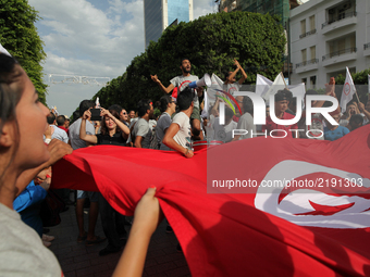 Protesters wave Tunisian flag and shout slogans during a march held under the slogan ‘firmness against the mafia regime’ by the movement "I...