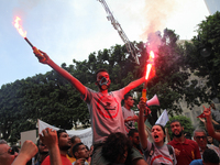 Protesters shout slogans as they hold smoke grenades during a march held under the slogan ‘firmness against the mafia regime’ by the movemen...